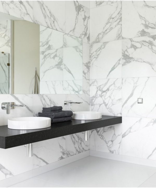 Cuarto de baño con azulejos porcelánicos pulidos imitación mármol.